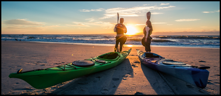 Rob Nelson and Haley Chamberlain on the beach with kayaks